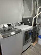 Washroom featuring laundry area, wood finished floors, and independent washer and dryer