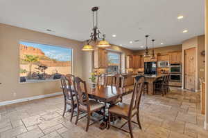 Dining area featuring stone tile floors, visible vents, baseboards, and recessed lighting