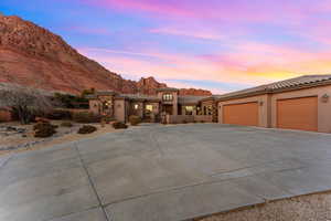 Mediterranean / spanish-style home featuring a tile roof, stucco siding, concrete driveway, an attached garage, and a mountain view