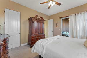 Bedroom featuring light colored carpet, ceiling fan, and baseboards