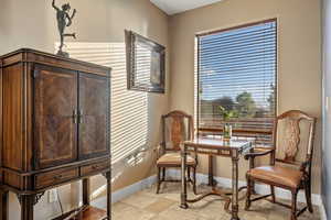 Sitting room with baseboards and stone tile floors