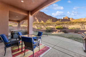 View of patio / terrace featuring a hot tub, a mountain view, and a fenced backyard