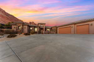 Mediterranean / spanish-style house with an attached garage, driveway, a tiled roof, and stucco siding