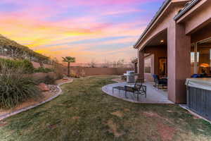 Yard at dusk featuring a patio and a fenced backyard