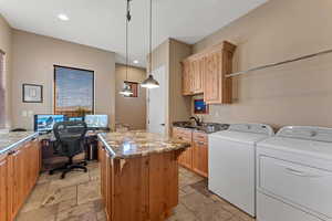 Clothes washing area featuring recessed lighting, cabinet space, independent washer and dryer, and stone tile floors