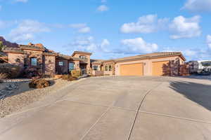 Mediterranean / spanish home with a garage, stone siding, a tile roof, and stucco siding