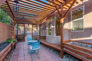 View of patio featuring a fenced backyard, a vegetable garden, and a pergola