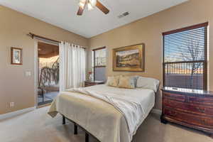 Bedroom with light carpet, visible vents, baseboards, a ceiling fan, and access to exterior