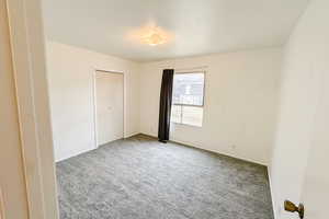 Unfurnished bedroom with carpet floors and baseboards