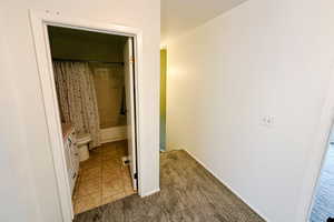 Bathroom with shower / bath combo, baseboards, vanity, and toilet