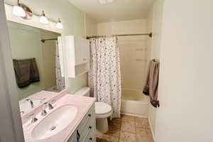 Full bathroom with visible vents, shower / bath combo, vanity, and toilet