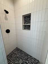 Full bath featuring a tile shower