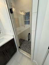 Full bathroom featuring a stall shower, vanity, and tile patterned floors