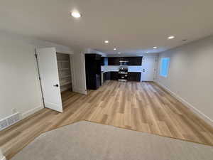 Unfurnished living room featuring light wood-style floors, recessed lighting, visible vents, and baseboards