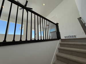 Stairway featuring visible vents, vaulted ceiling, and recessed lighting