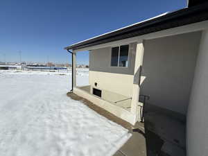 View of snowy exterior featuring stucco siding