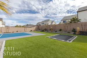 View of yard with basketball hoop and a fenced backyard