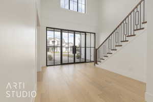 Foyer entrance featuring stairs, plenty of natural light, baseboards, and wood finished floors