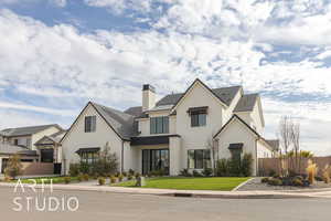 View of front of property featuring metal roof, fence, a residential view, stucco siding, and a standing seam roof