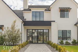 Exterior space featuring brick siding, a chimney, and stucco siding