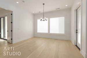 Unfurnished dining area featuring light wood-style flooring, recessed lighting, visible vents, and an inviting chandelier