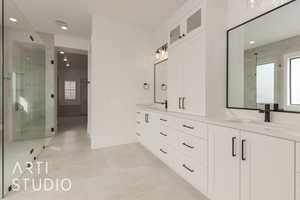 Bathroom featuring double vanity, recessed lighting, a sink, a shower stall, and baseboards