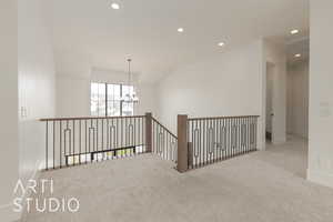 Hallway with recessed lighting, light carpet, baseboards, and an inviting chandelier