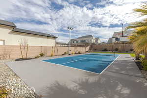 View of sport court featuring fence and a residential view