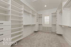 Walk in closet with light carpet