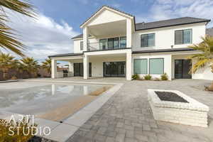 Back of house featuring a patio area, area for grilling, a balcony, and stucco siding