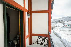 Snow covered back of property with a mountain view
