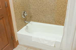 Full bath featuring a washtub and tile patterned flooring