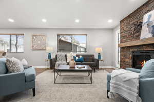 Living area with LVP flooring, an electric fireplace, and recessed lighting