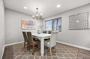 Dining space with an inviting chandelier, LVP flooring, and recessed lighting