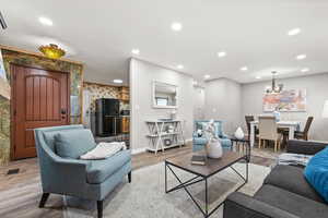 Living area with LVP flooring, an electric fireplace, and recessed lighting