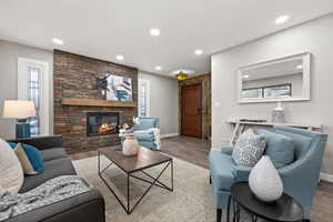 Living area with LVP flooring, an electric fireplace, and recessed lighting