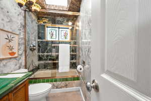 Full bathroom featuring tiled shower / bath combo, toilet, and vanity