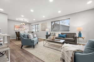 Living area with LVP flooring, an electric fireplace, and recessed lighting