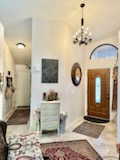 Foyer with a chandelier and lofted ceiling