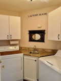 Laundry room with sink, cabinets