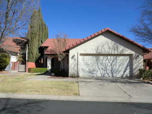 Mediterranean / spanish-style house featuring a garage and a front yard