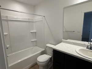 Full bathroom featuring  shower combination, vanity, toilet, and wood finished floors