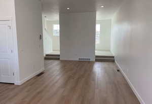 Spare room featuring baseboards, visible vents, wood finished floors, and recessed lighting