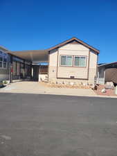 Manufactured / mobile home with concrete driveway and an attached carport