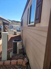 View of side of property with a mountain view and central AC unit