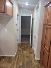 Hall featuring dark wood-type flooring, visible vents, and baseboards