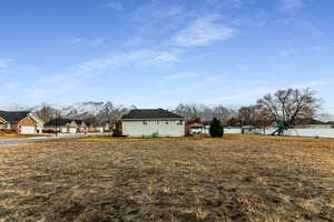 View of yard with fence, a mountain view, and a playground