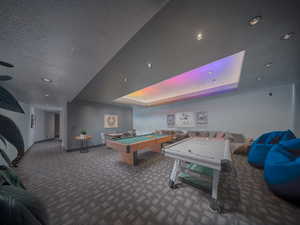 Playroom featuring a textured ceiling, recessed lighting, carpet flooring, baseboards, and a tray ceiling