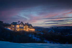 Snow covered house featuring a mountain view.