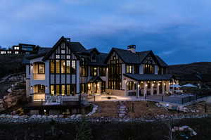 Back of property with stucco siding, a fire pit, a chimney, and a patio